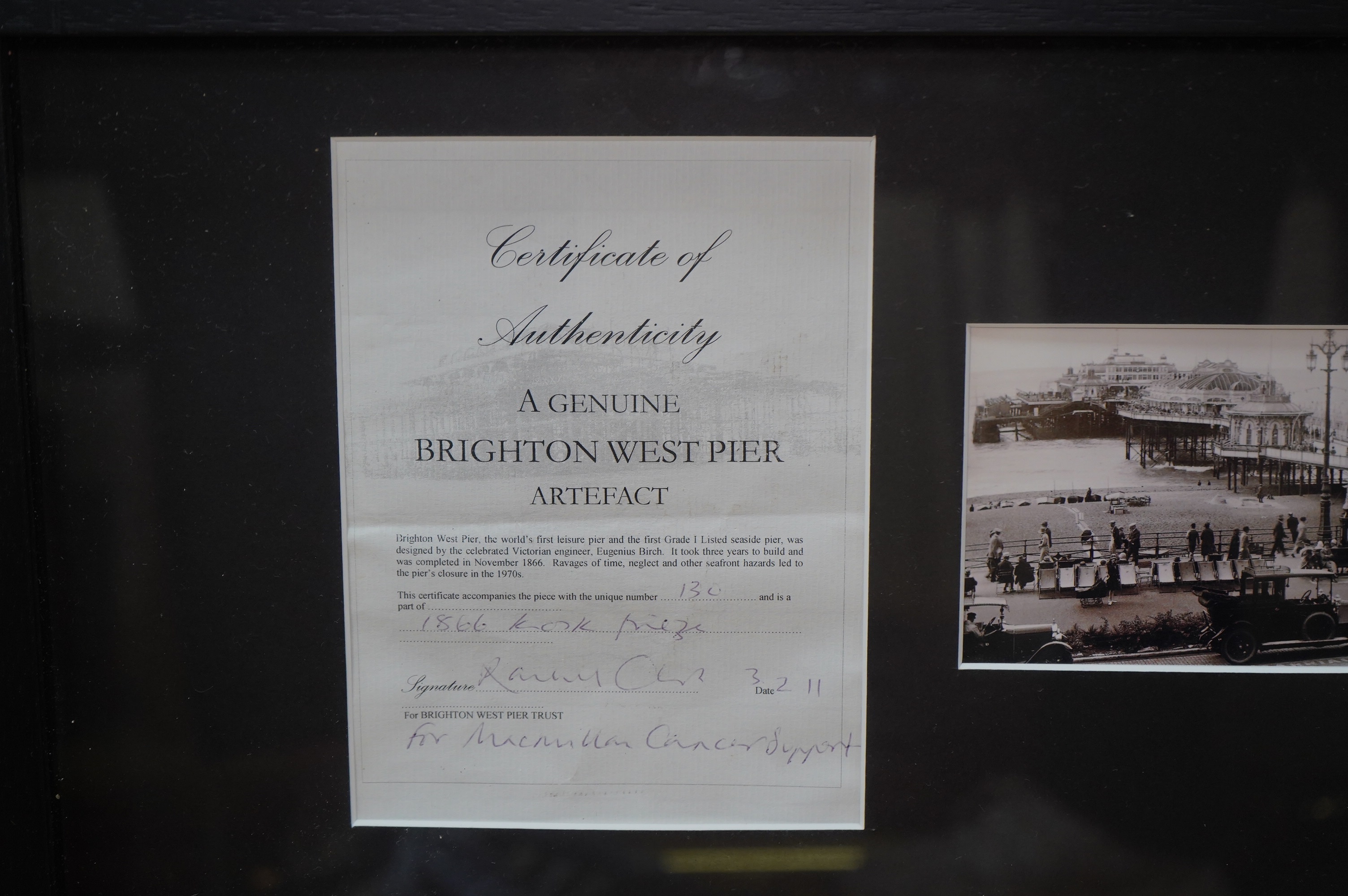 A framed part of the original frieze from the West Pier in Brighton, a photo and certificate, plus a book about the West Pier, 50cm wide, 40cm high. Condition - good